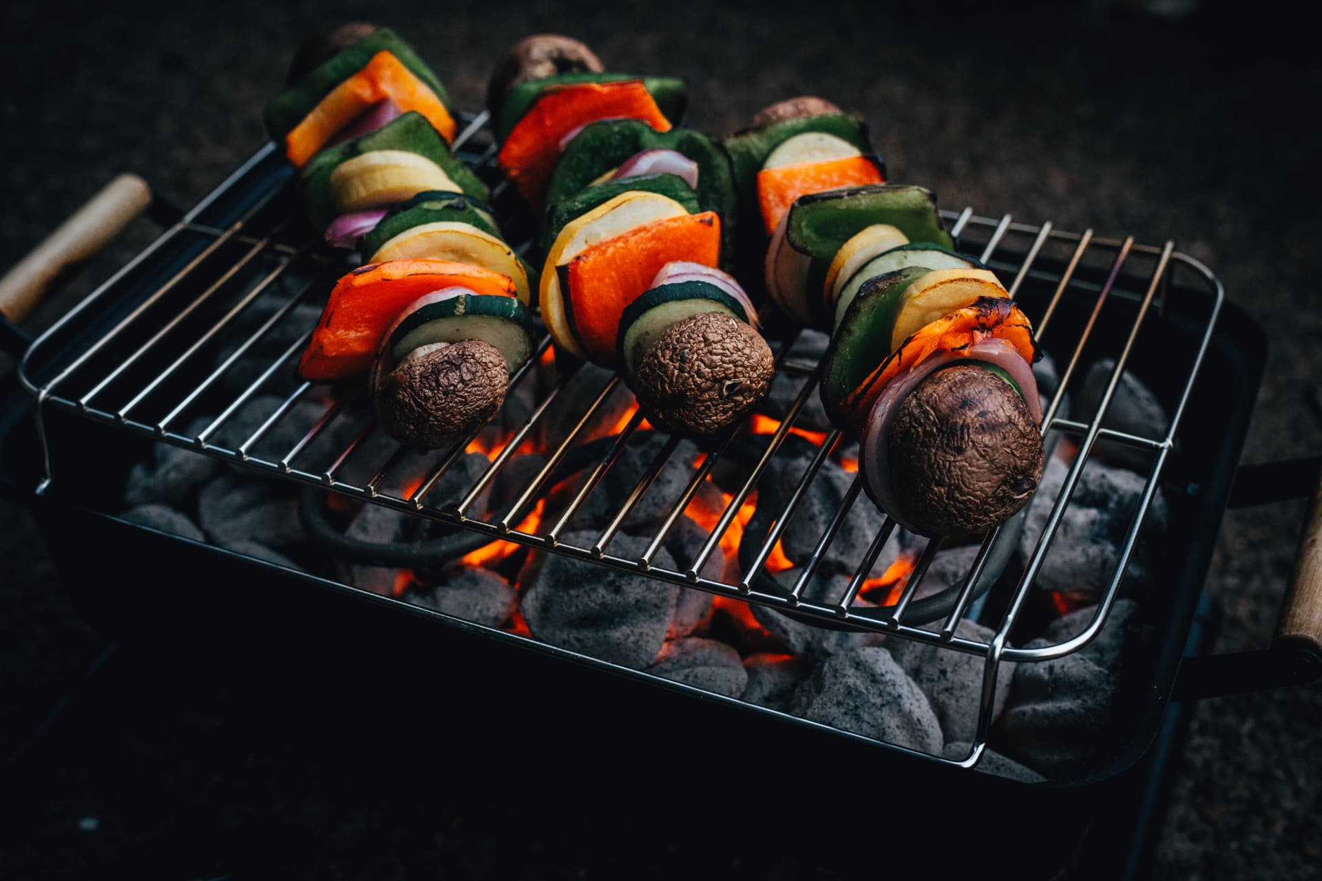 Colorful vegetable skewers searing over glowing charcoal on the Quick Start Grill
